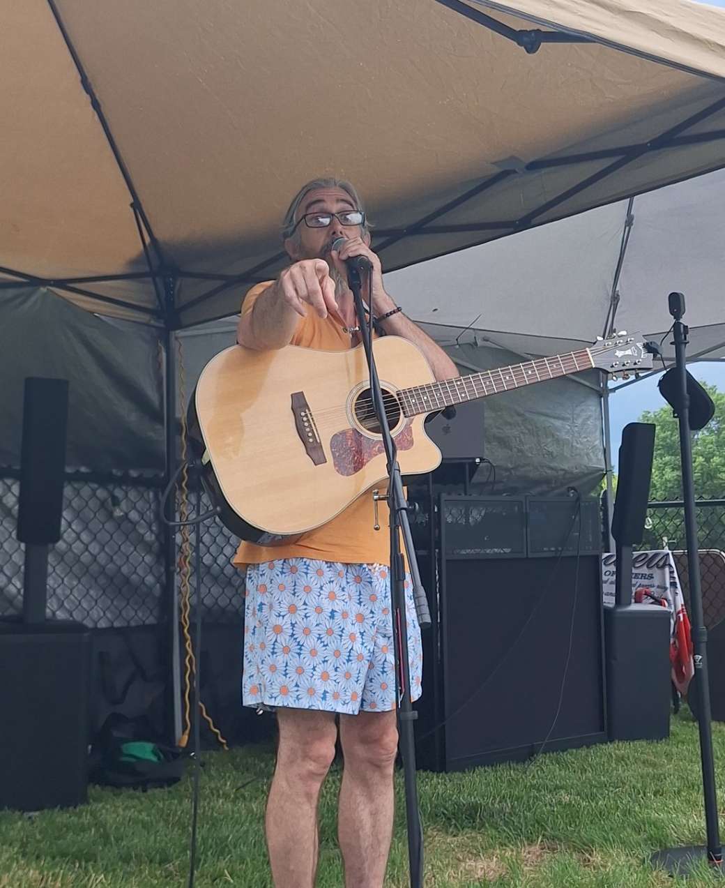 David Wayne Redfearn playing acoustic guitar and singing at a live outdoor set